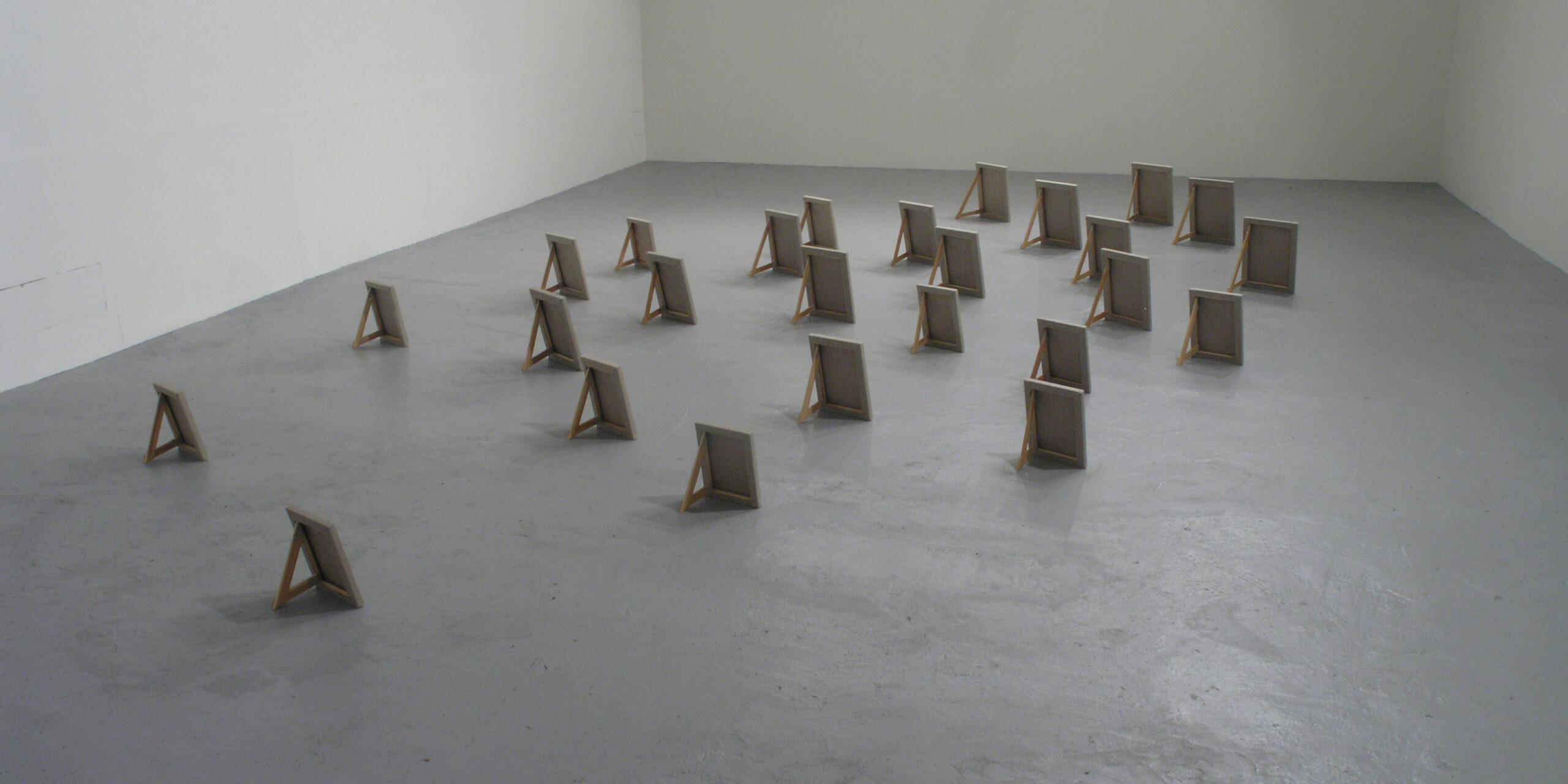 Jordnära, små målningar uppställda på golvet, gjorda av Anna Renström